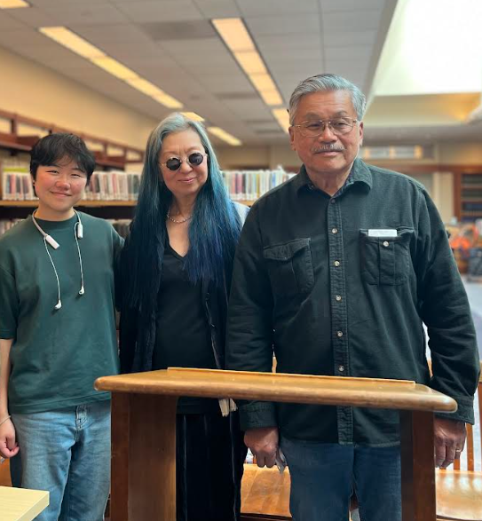 Jaide Lin, stands next to Faye Myenne Ng and Harvey Dong in a library.