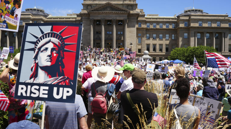 A sign with the Statue of Liberty that says "Rise Up"