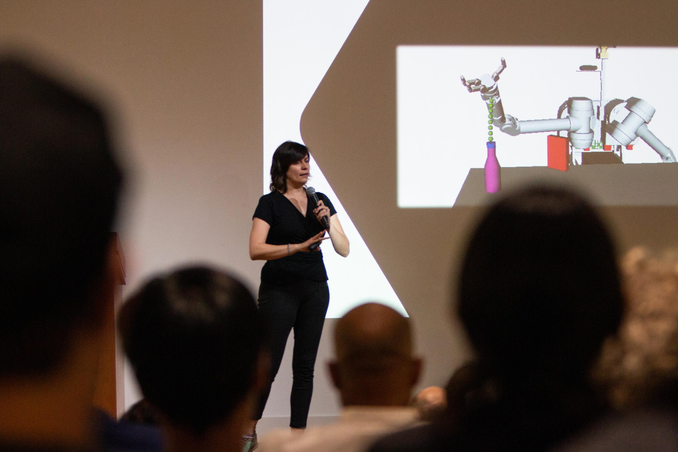 image of woman standing on stage giving a talk 