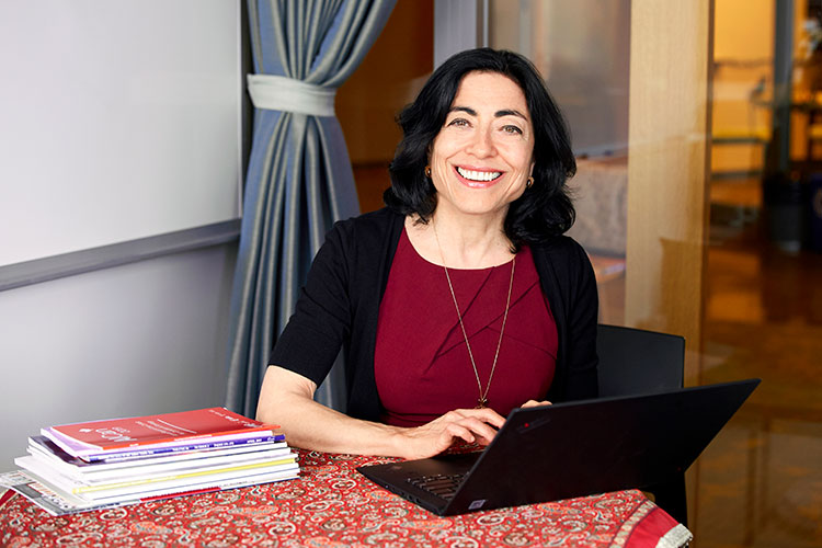 A photo of Jennifer Tour Chayes at a table with a laptop open in front of her