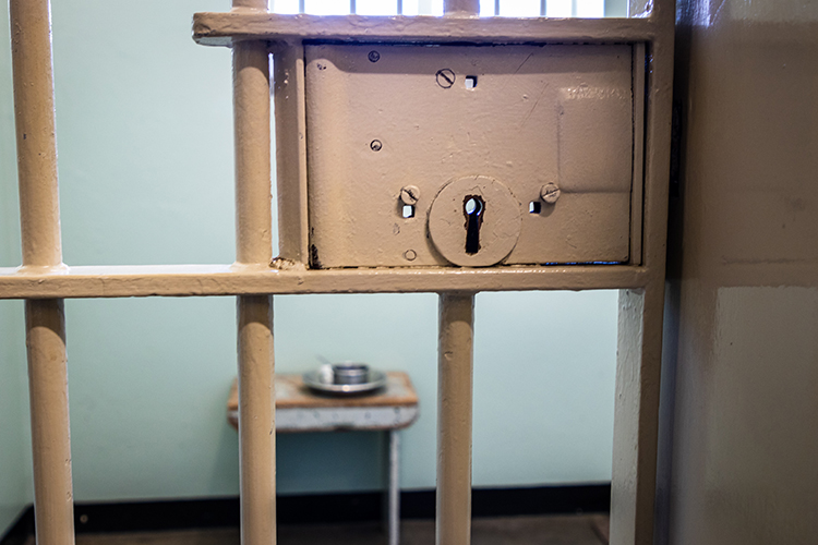 image of jail cell door lock with table in background