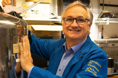 Jeff Reimer in blue lab coat near stainless steel tank
