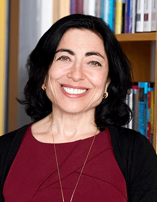 A headshot of Jennifer Chayes, smiling and standing in front of a bookcase
