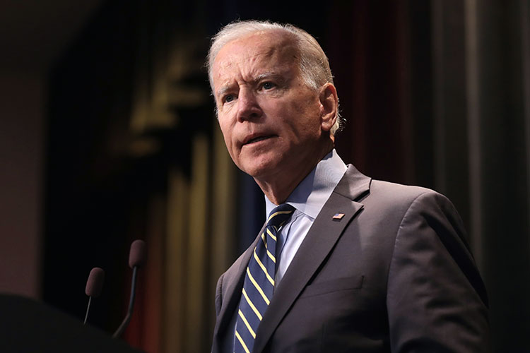 President Joe Biden speaks, with a serious expression