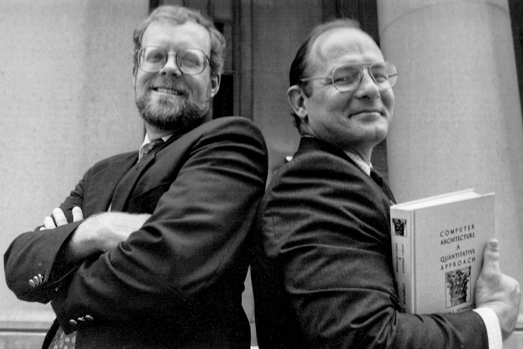 Portrait of John Hennessy and David Patterson, Patterson is holding a Computer Architecture and Quantitative Approach