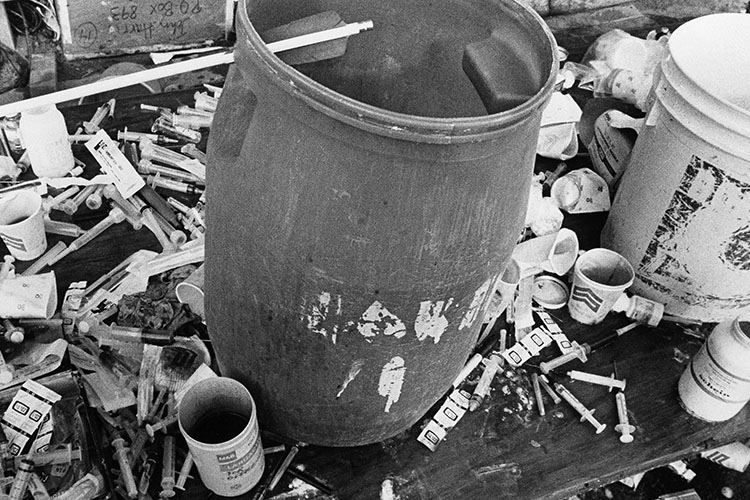Syringes and cups surround vats filled with cyanide that were used in a mass suicide and mass murder event in November 1978 in Jonestown, Guyana.