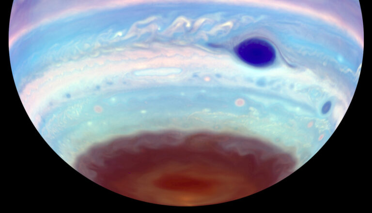 the southern portion of a blue Jupiter with a dark blue spot and a chocolate-brown cap at the bottom