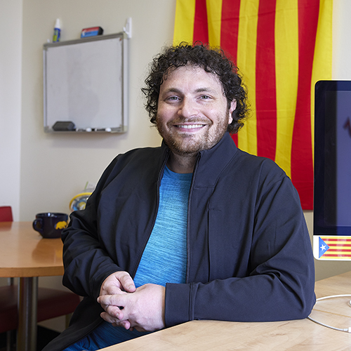 image of man sitting at a desk smiling