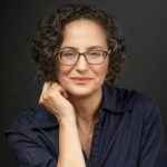 headshot of woman resting face on hand