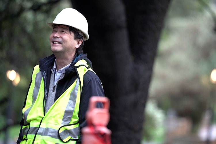 A photo of Kenichi soga wearing a hard hat and a vest