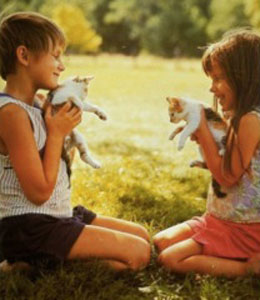 Two children playing with kittens.