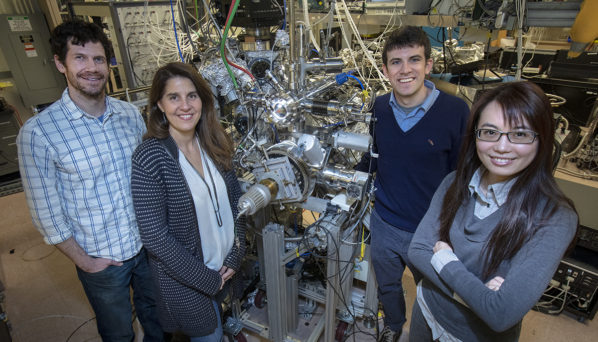 image of 4 people standing in front of a machine in a lab