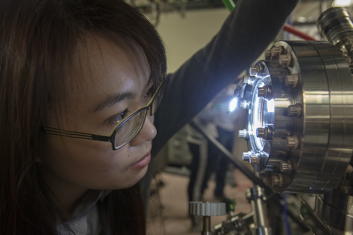 image of a woman looking through a lab machine