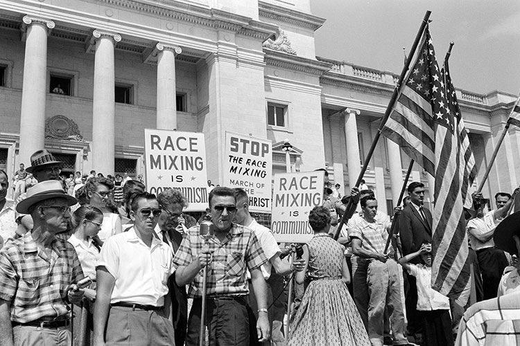 white protesters gather in opposition to school integration in Little Rock, Ark., in 1959. Signs read "Race Mixing is Communism" and "Stop the Race Mixing | March of the Antichrist"