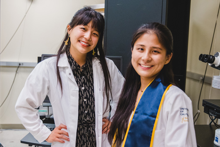 two young women researchers in white coats