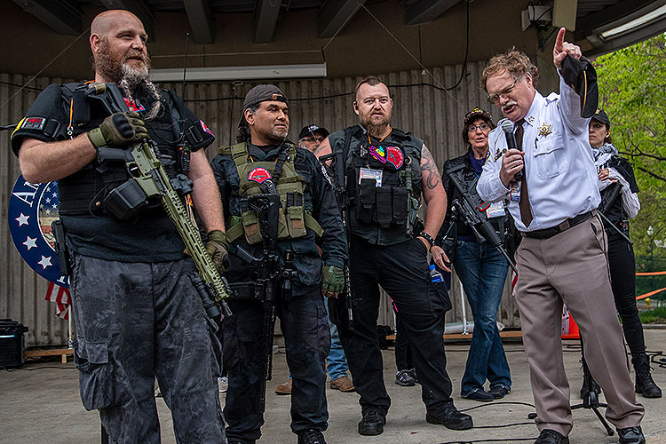 Dar Leaf, front right, sheriff of Barry County, Michigan, speaks next to militia members in May 2020 during a May 2020 protest of Whitmer's stay-at-home order during the coronavirus pandemic.