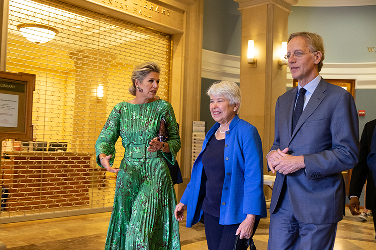 The Dutch queen, the chancellor and the Dutch minister of education, culture and science walk out of Morrison Library talking to each other on the way.
