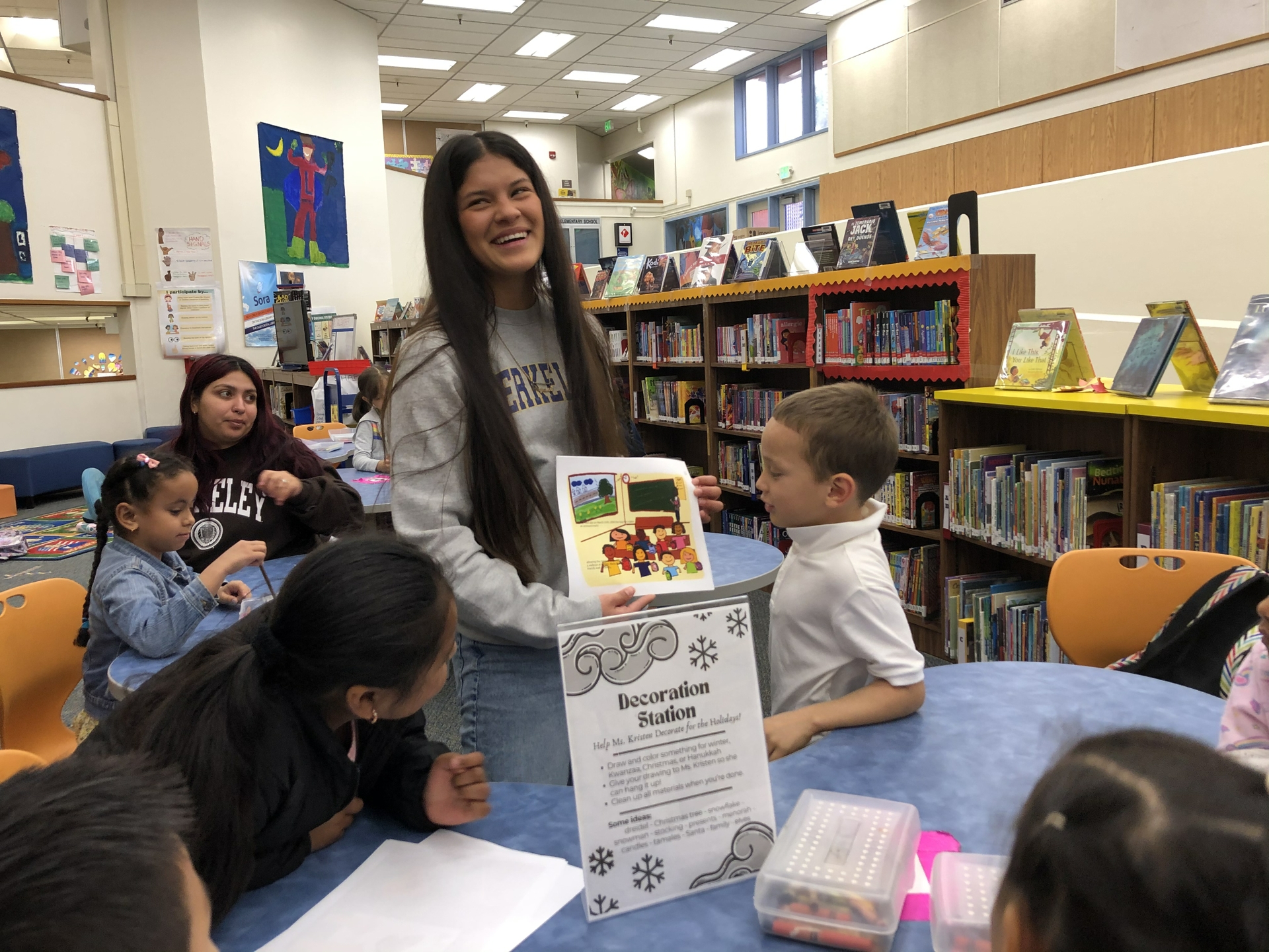 Dayane Silva smiles as a student prods at her children's book in a school library.