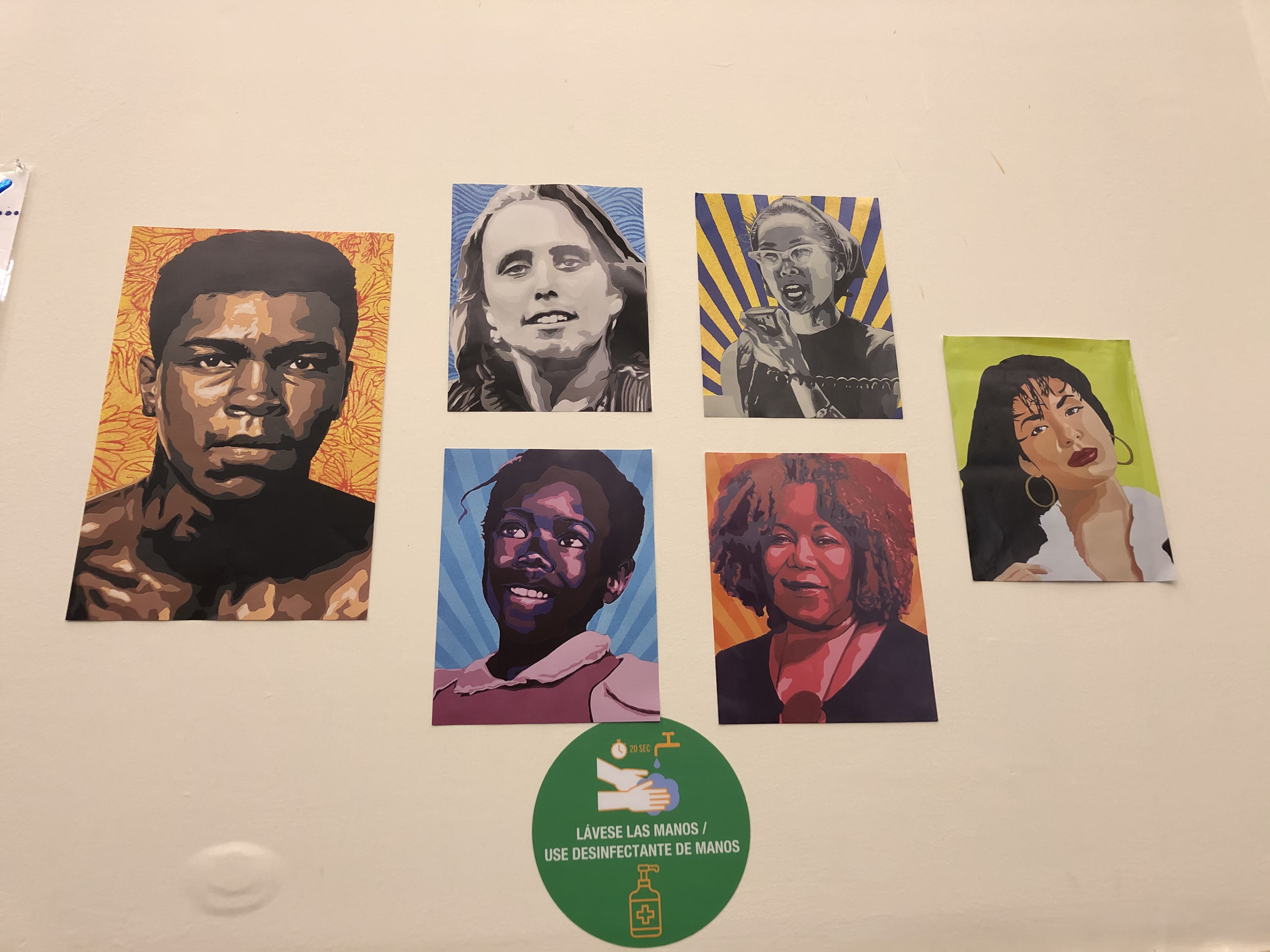 A wall with photos of various iconic people of color including Muhammad Ali and Yuri Kochiyama.