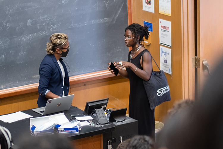 Associate professor of English Poulomi Saha talks with a student in her lecture class.