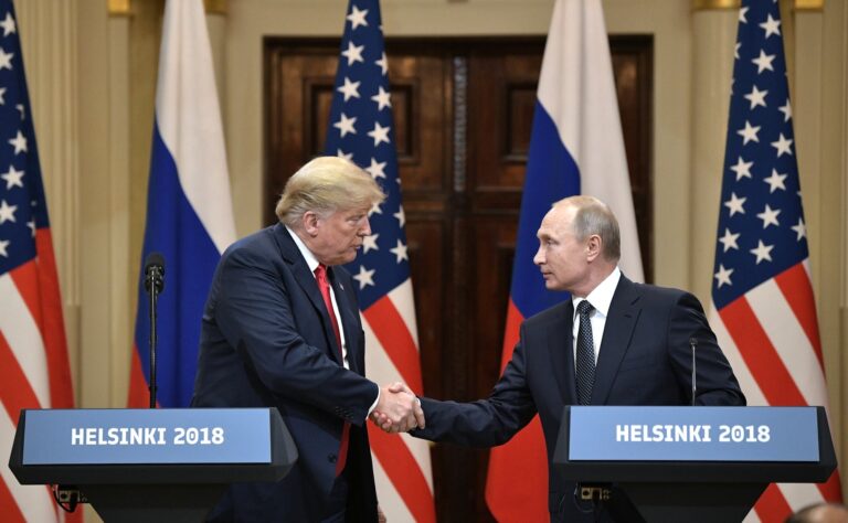 Donald trump, left, shakes the hand of Vladimir Putin, right, standing in front of USA and Russia flags.