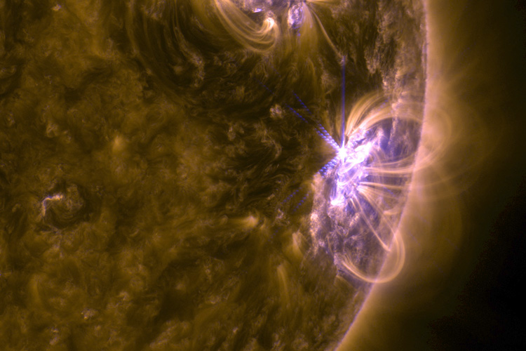 closeup of a solar flare in purple arcing out of the sun