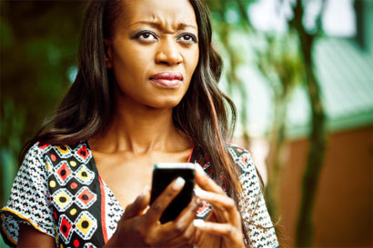 Woman looks frustrated, holding a phone