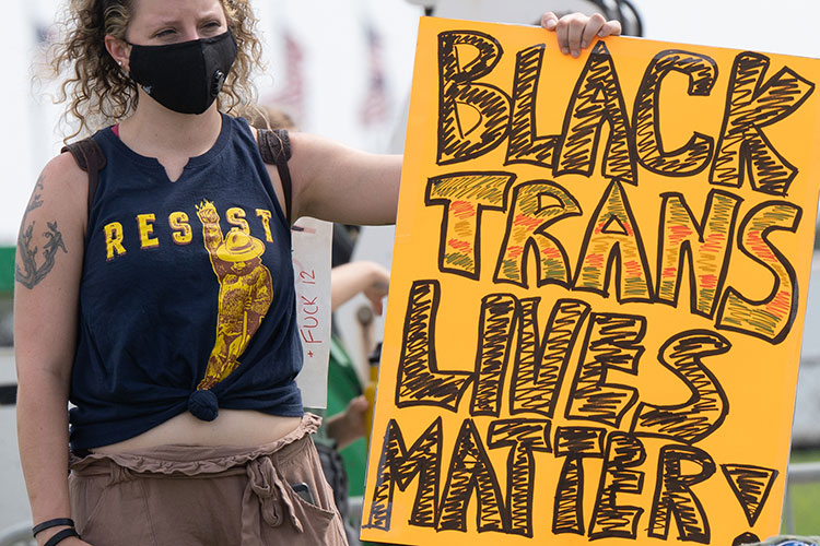 Women holding a sign that reads: Black Trans Lives Matter