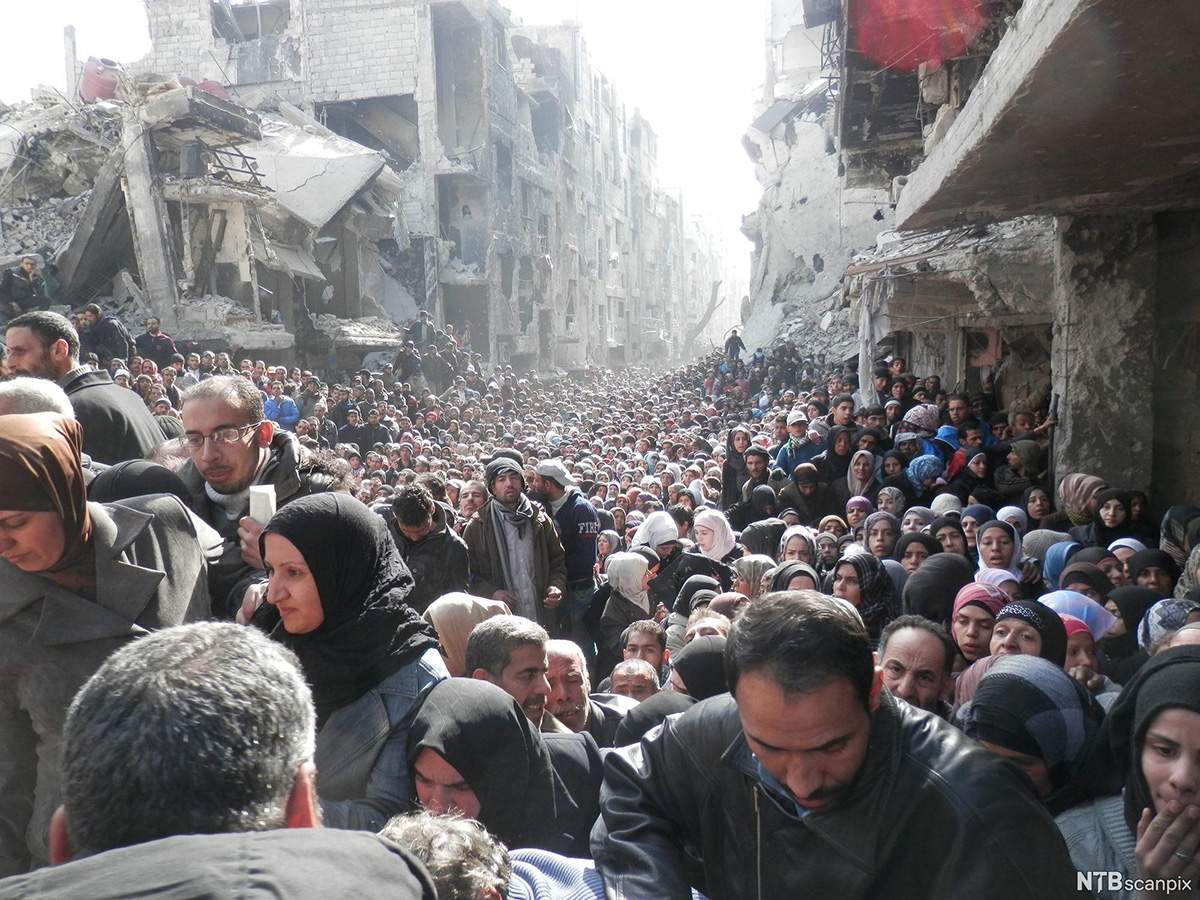 Palestinian refugees mass in a war-ravaged district on the outskirts of Damascus, Syria, in 2014Syrians in bombed-out city 2015