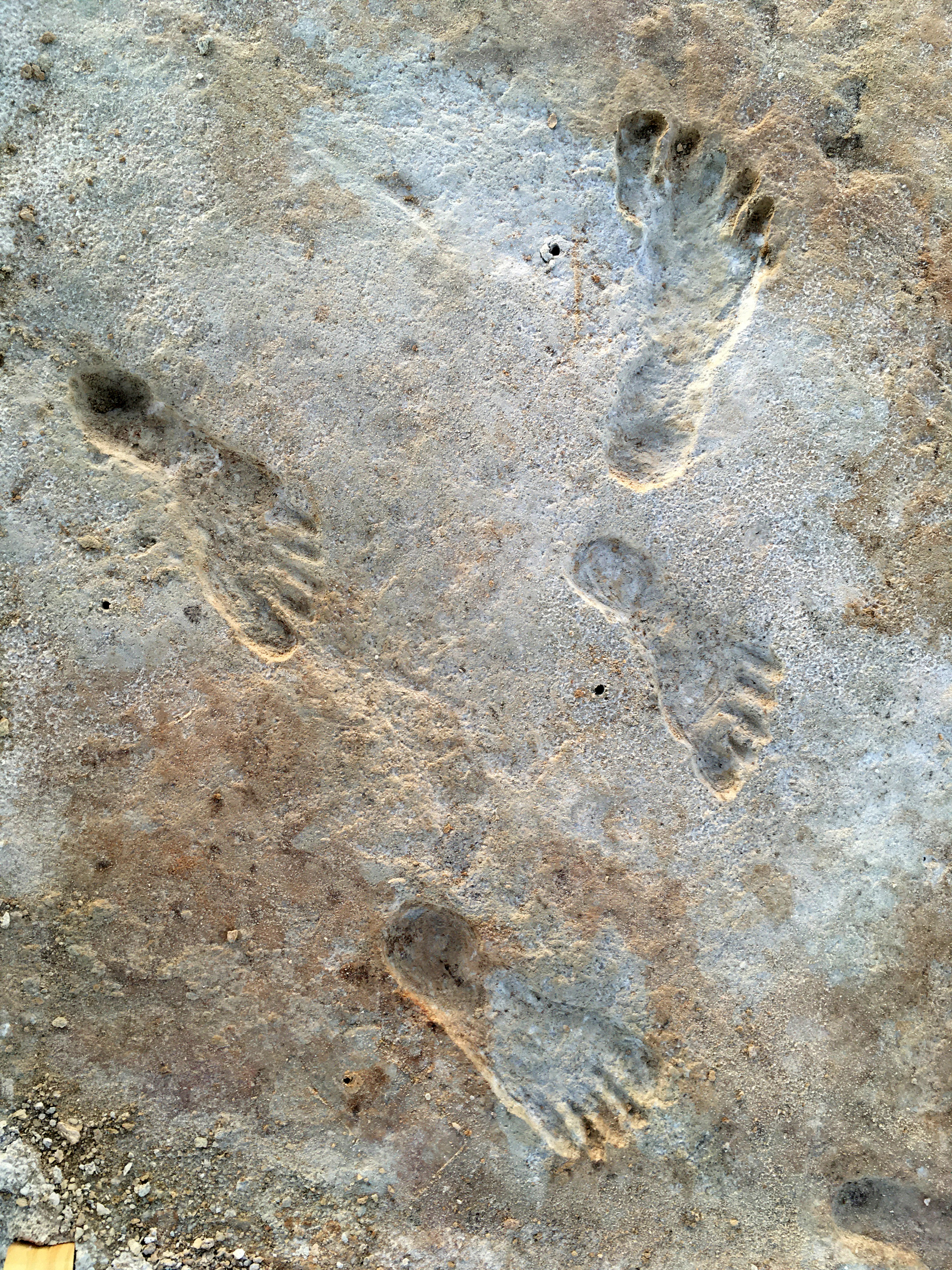 4 human footprints in white and reddish rock