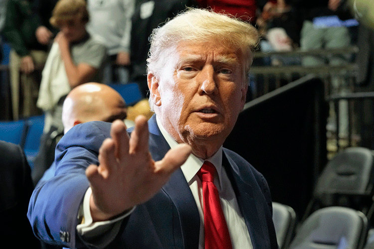 Former President Donald Trump, with an apprehensive expression, waves at supporters