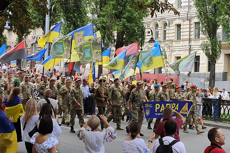 Ukrainian soldier carrying many flags parade to celebrate the country's independence de on