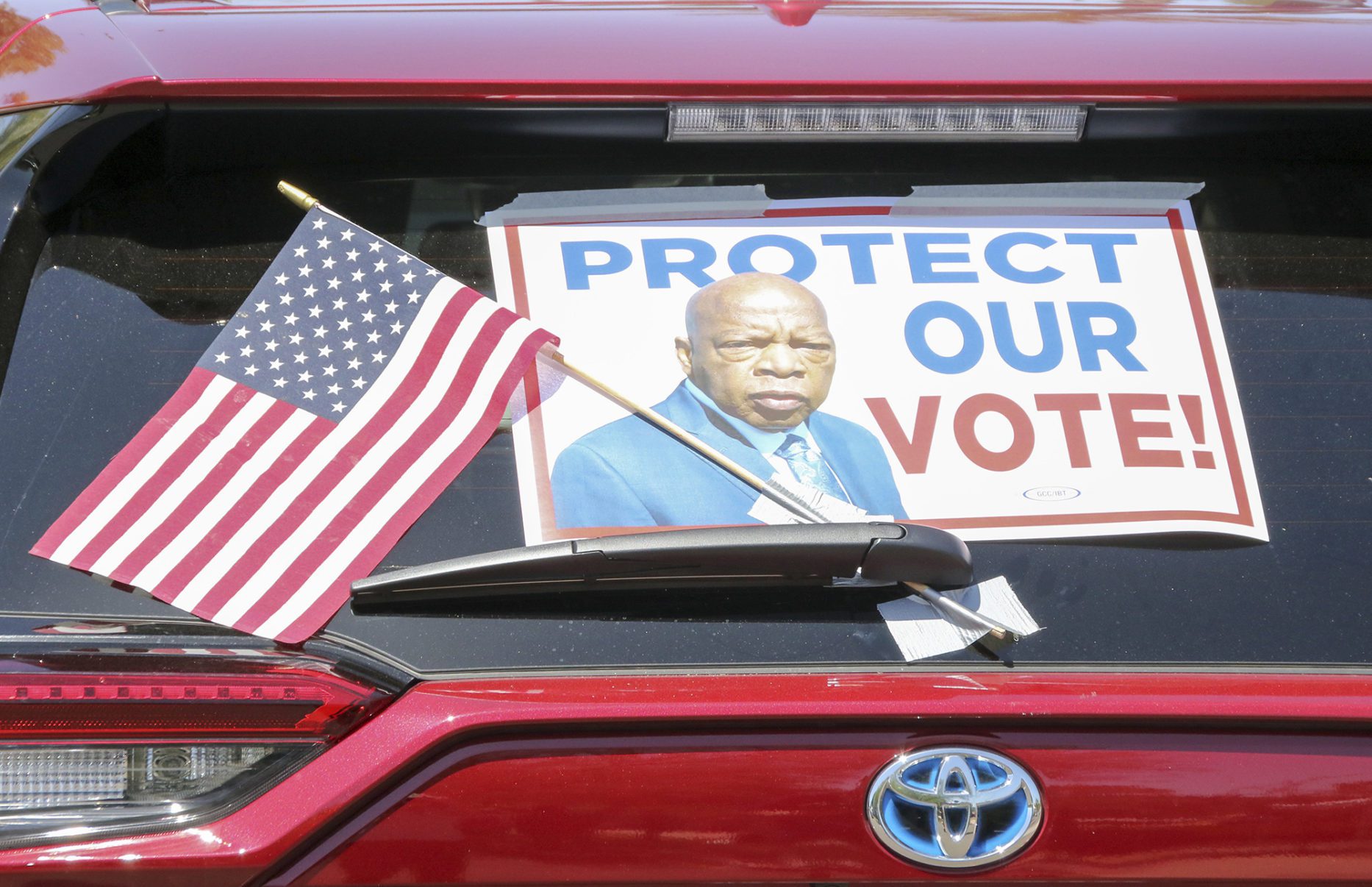 A car waits in line at the John Lewis Voter Advancement Day Votorcade