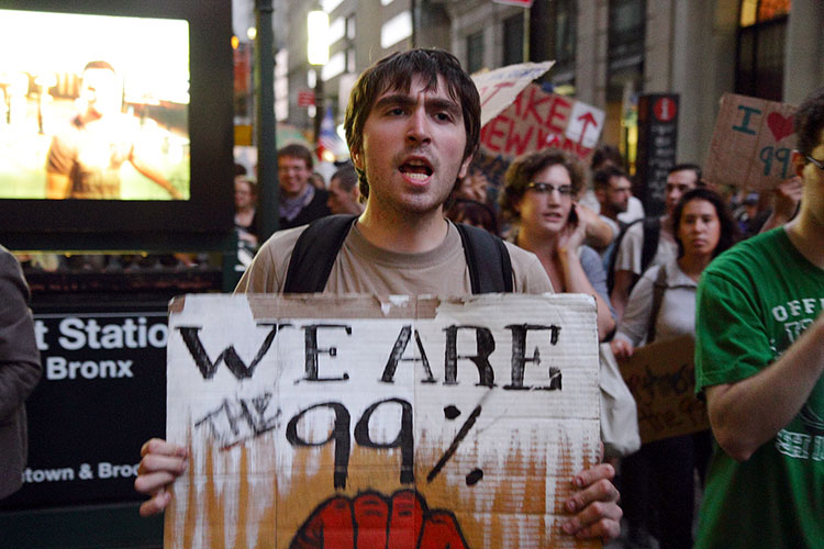 Protester carries sign that says "We are the 99%"