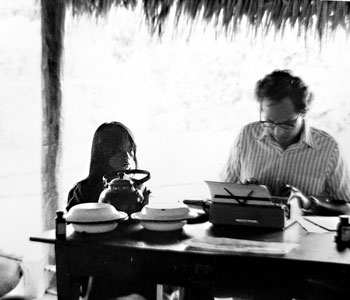 Anthropologist Gerald Weiss at typewriter with a member of the Ashaninka community on the River Tombo in the Peruvian Amazon in the early 1960s.