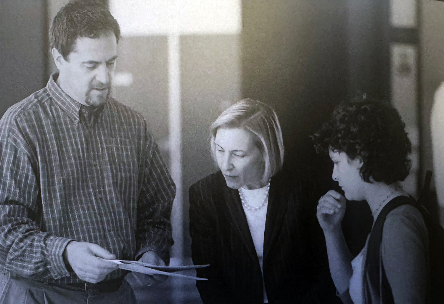 Weisselberg, Semel, and Sommovilla looking at paper