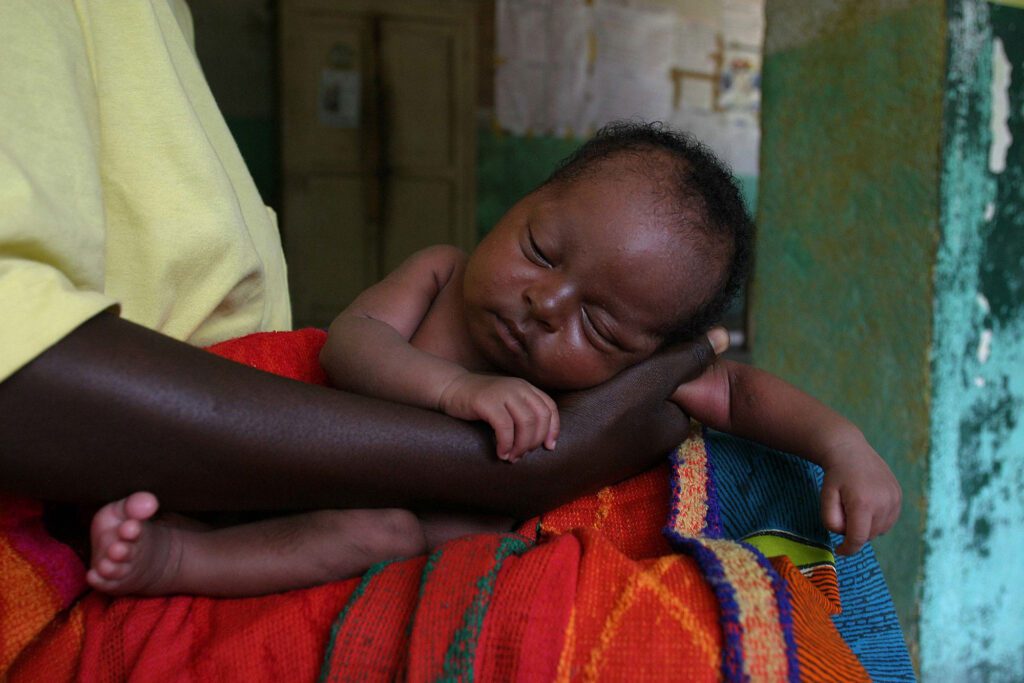 image of baby sleeping on mother's arm 