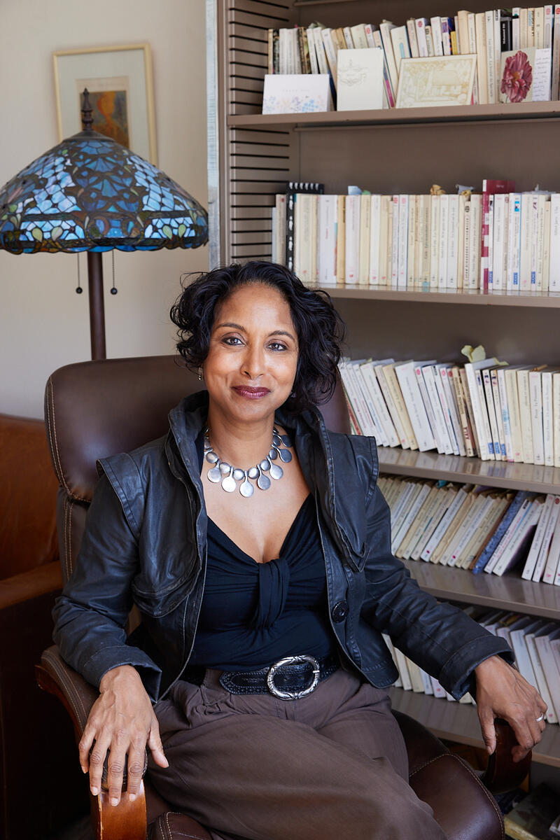 person sitting in a chair in front of a bookshelf