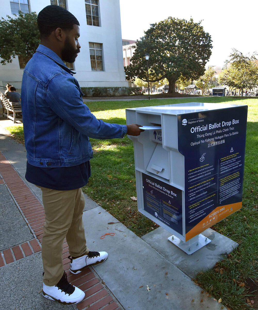 image of a man dropping ballot in a ballot drop box