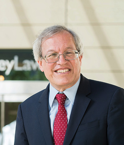 headshot of man in glasses smiling