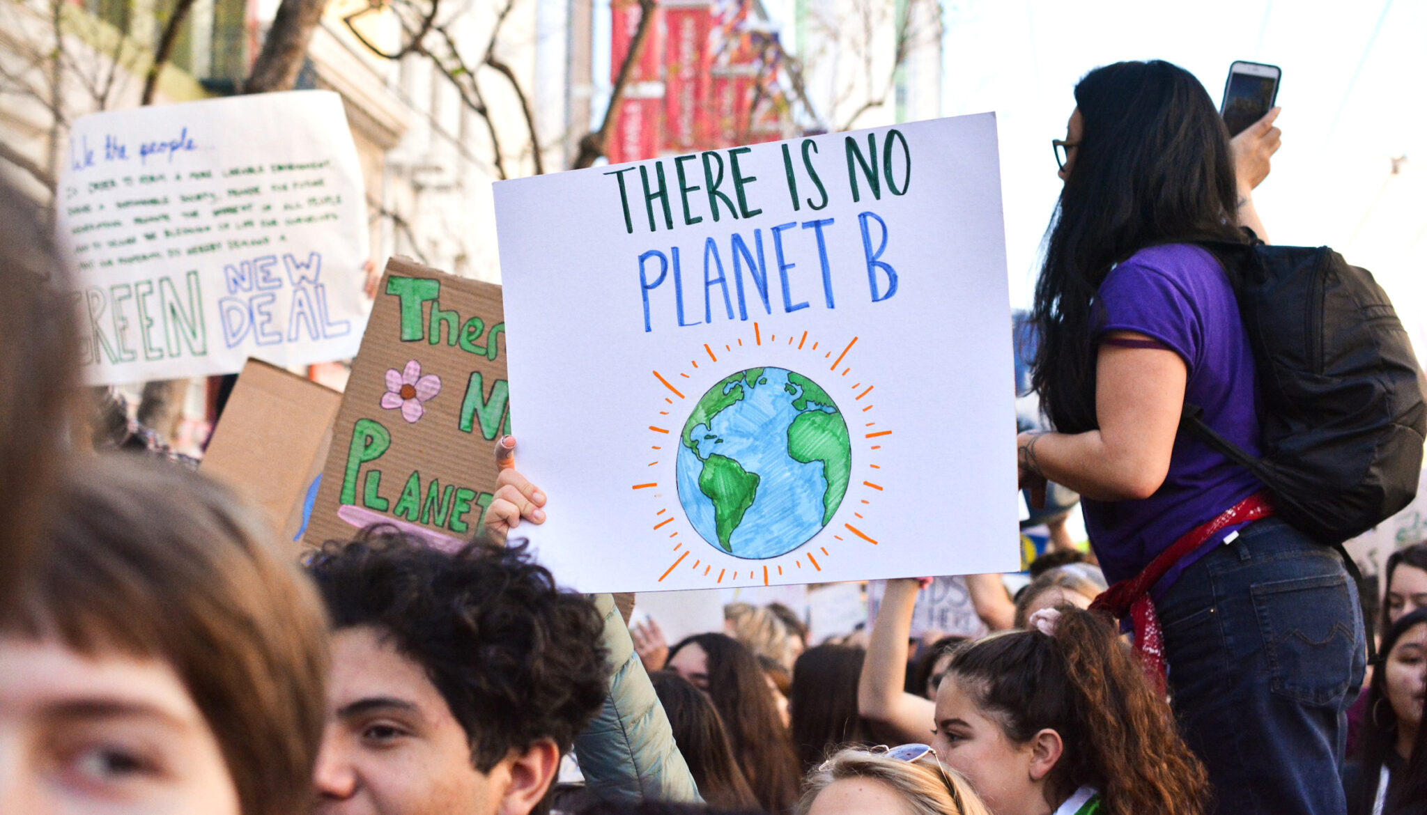 a sign held up by a protestor that says "there is no planet B" with a drawing of the earth