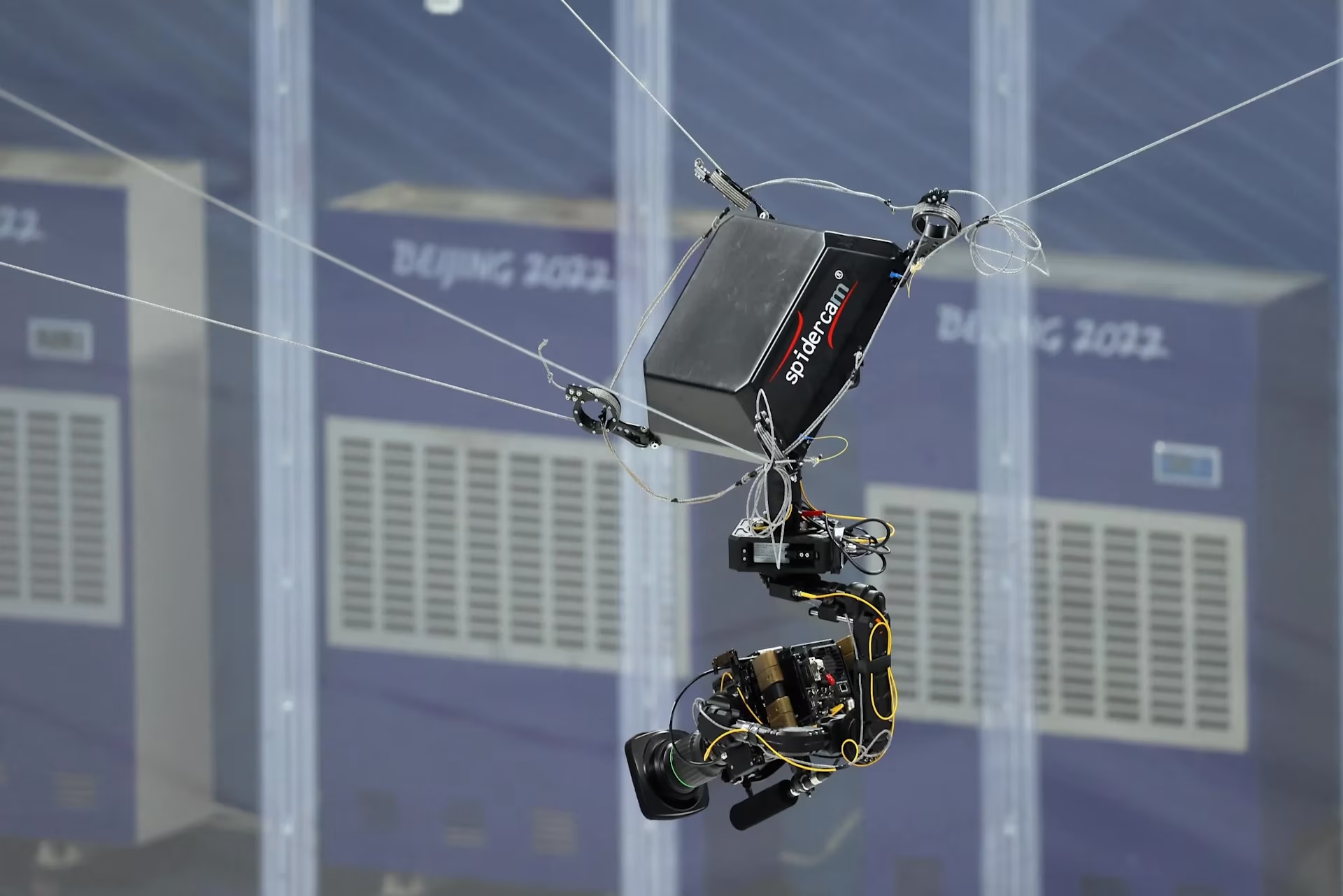 a camera mounted to a pully system is suspended above an arena during the Beijing Olympics. Over 1,000 cameras showing in-depth action will be in use during the 2024 Paris Olympics.
