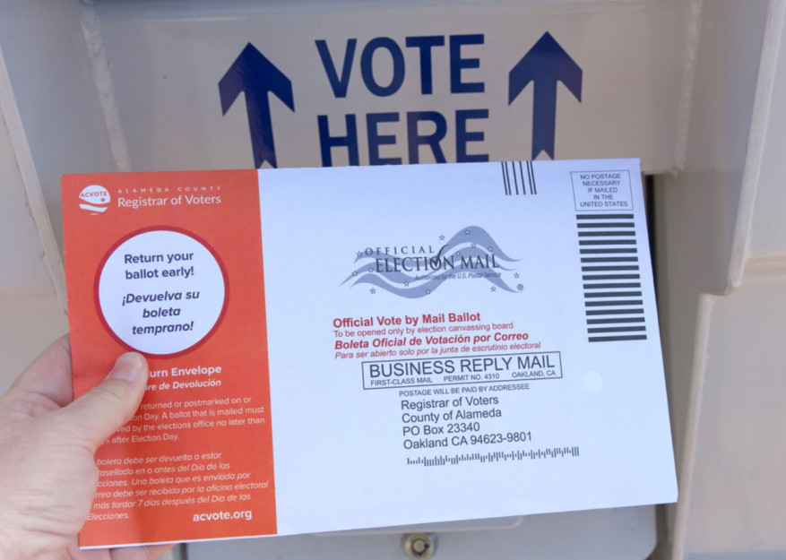 image of a hand holding a ballot