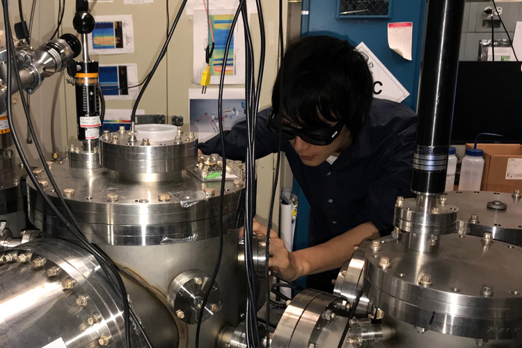 Yuki Kobayashi makes adjustments to an experiment in the basement of Hildebrand Hall.