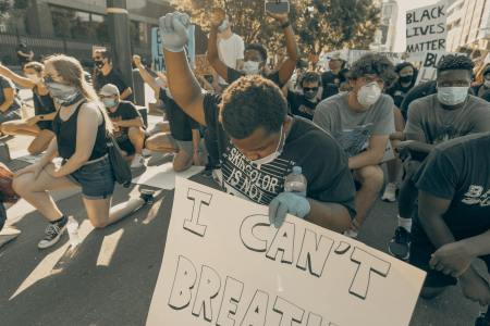 Protestor holding up his fist in solidarity in Charlotte, NC (Photo: Clay Banks via Unsplash)