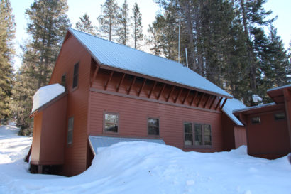 reddish wooden building in snow