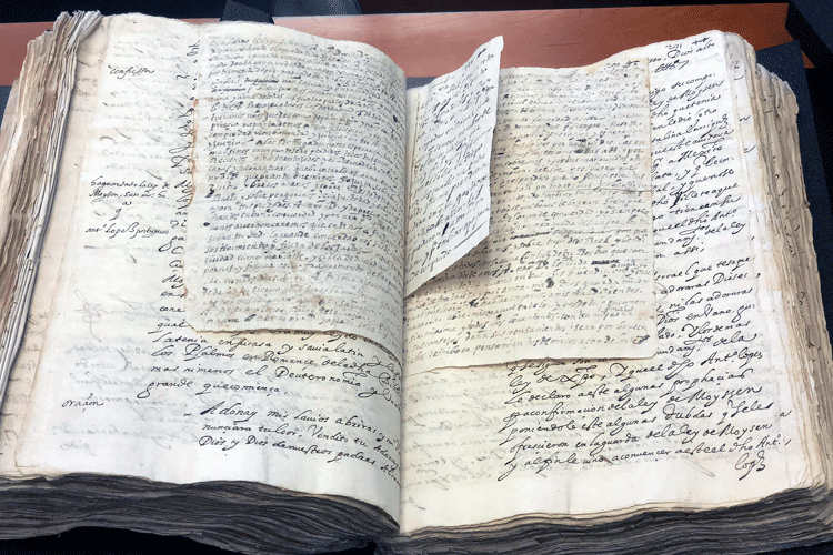 A 1,334-page text documents the trial of Manuel de Lucena, after his arrest in 1594. Visible among the parchment pages, is a letter from Manuel de Lucena to his wife, Catalina Henríquez.