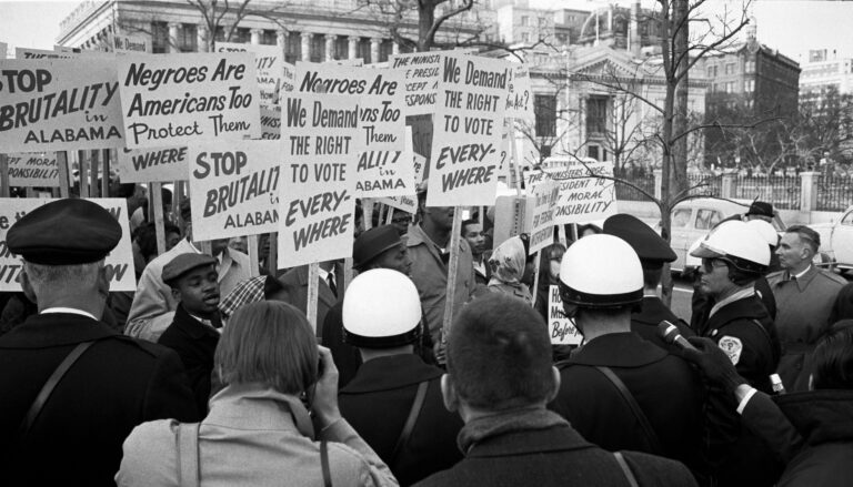 Protesters in 1965 fathered outside the White House carrying signs saying "We demand the right to vote everywhere."