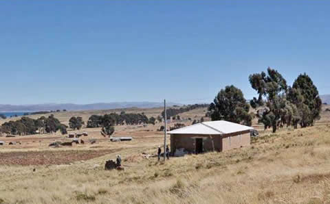 A small museum building sits on a grassy hill.