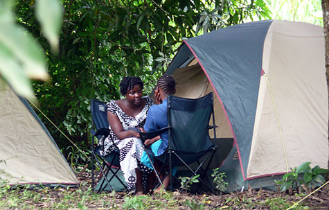 A conselor talks to a women outside of a tent.